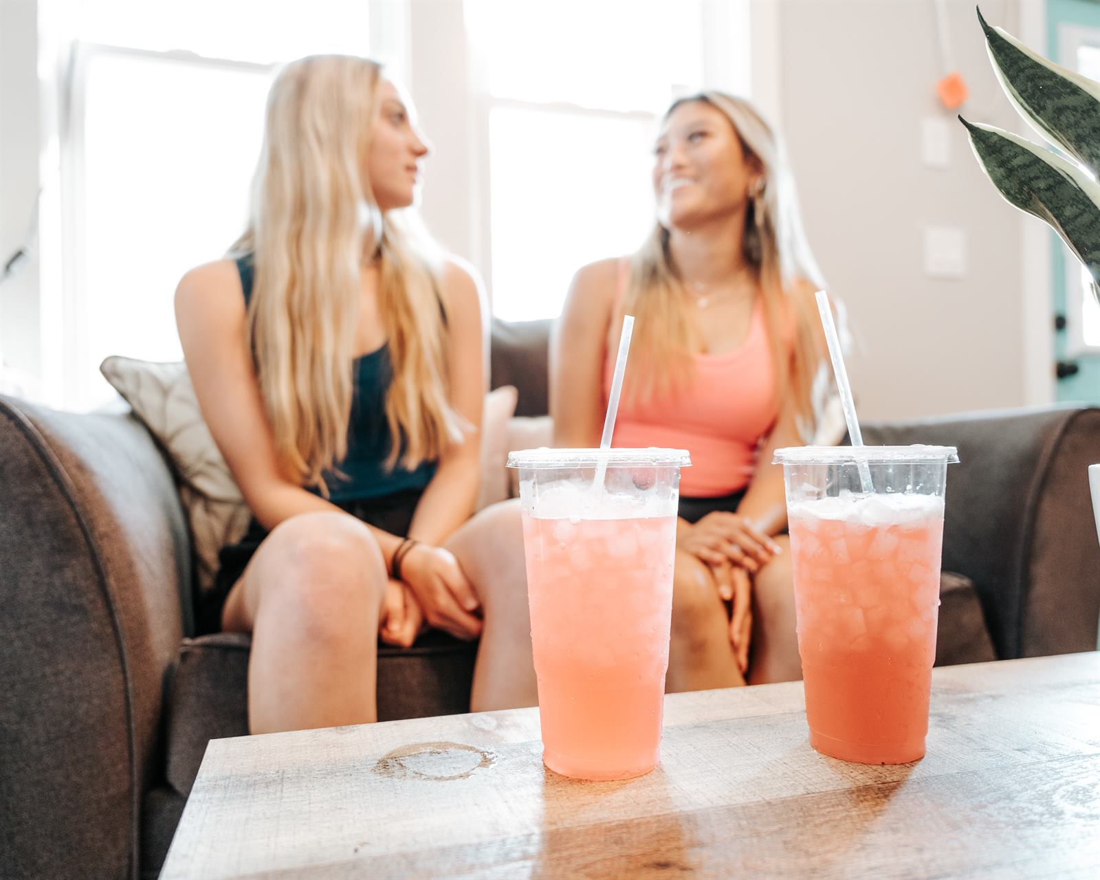 Two friends on the couch with matching pink teas