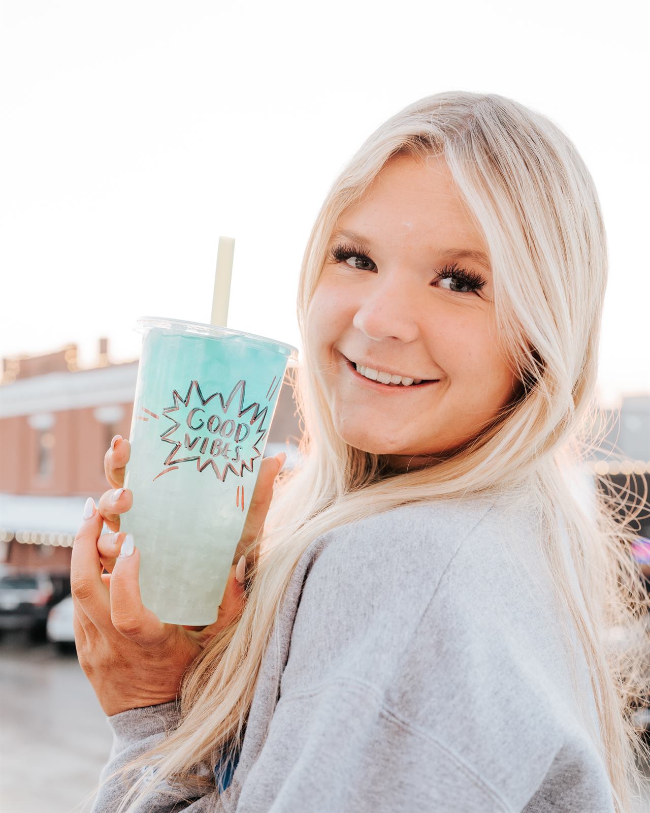 Gabby holding a Good Vibes teal tea